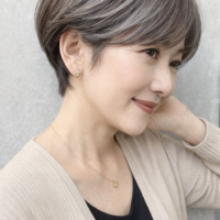 白髪ぼかしのハイライトで顔まわりを明るくした女性の笑顔のアップ